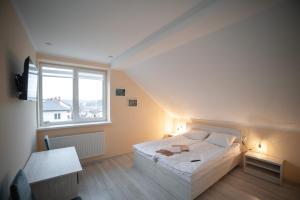 um quarto com uma cama grande e uma janela em Green Hill em Lviv