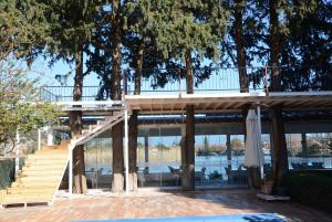 a house with a deck and stairs and trees at Berg Hotel in Dalyan