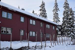 a red building in the snow with trees at Skeikampen Booking in Svingvoll