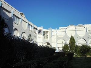 a white building with arches on the side of it at studio in Le Grau-du-Roi