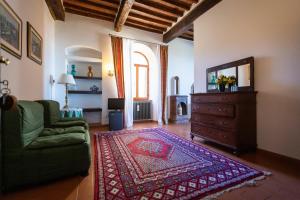 a living room with a couch and a tv and a rug at Albergo Santa Chiara in Sarteano