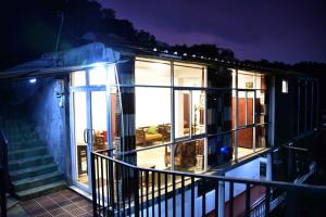 a house with windows and a balcony at night at Lodge in 611 in Kandy