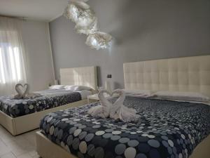 zwei Schwäne auf einem Bett in einem Schlafzimmer in der Unterkunft Sweet House Self Check-in 24h in Cavallasca