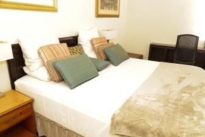a bedroom with a white bed with pillows on it at HOTEL MALLIKA COMPANY, SL in Freetown