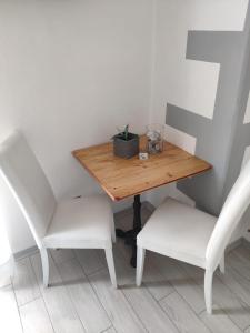 a table and two white chairs and a wooden table and chairs at Sweet House Self Check-in 24h in Cavallasca
