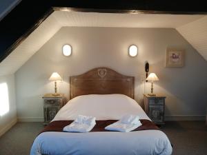 a bedroom with a bed with two pillows on it at Logis Hôtel Le Bretagne in Le Vivier-sur-Mer