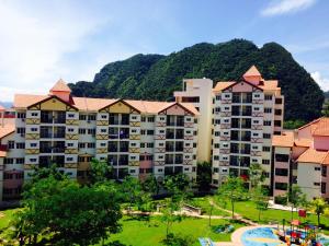 a large apartment building with a mountain in the background at Twin Luck Home Stay in Ipoh