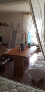 sala de estar con mesa de madera y cama en Kuća u uvali Surbova en Punat