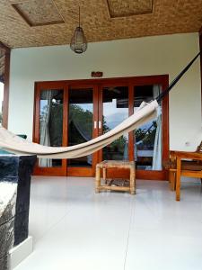 a hammock in the middle of a room with windows at Bamboo Bali in Amed