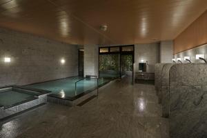 a swimming pool in a building with a pool at Royal Twin Hotel Kyoto Hachijoguchi in Kyoto