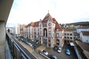 an old building on a city street with cars at Hôtel Fontaine Argent - Centre Ville in Besançon