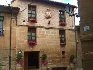 ein Steingebäude mit Blumenkästen an den Fenstern in der Unterkunft Casa Rural de Legarda in Briñas