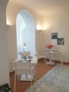 a living room with two tables and an archway at Relais Maresca Luxury Small Hotel & Terrace Restaurant in Capri