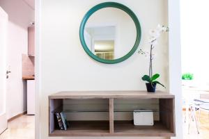 a mirror on a wall above a wooden console table at TONI'S Apartment near Seaside and Marina Flisvos in Athens