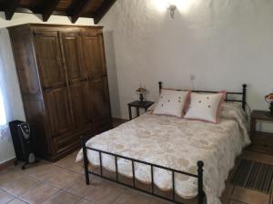 1 dormitorio con 1 cama y armario de madera en La Zamora, en Guarazoca