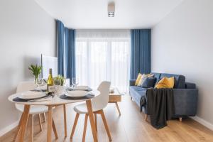 a living room with a table and a blue couch at Kamienica Parkowa in Dąbki +97 photos
