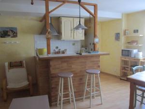 una cucina con 2 sgabelli e bancone di Appartement Cauterets a Cauterets