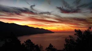 um pôr-do-sol sobre um corpo de água com montanhas em Albergo Suisse Bellevue em Monterosso al Mare