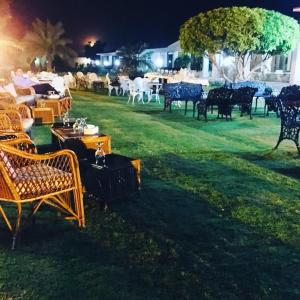 um grupo de cadeiras e mesas num quintal à noite em Etihad Club by Faletti's Hotel em Rahimyar Khan