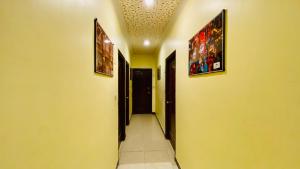 a hallway with yellow walls and two pictures on the ceilings at Tuk Tuk Backpackers- Near Jaipur Train Station in Jaipur