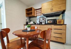 a small kitchen with a wooden table and chairs at Timur Bay Seafront Residence Kuantan in Kuantan