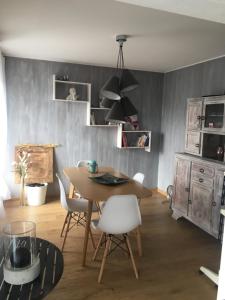 a dining room with a table and white chairs at Quatre à Metz in Metz