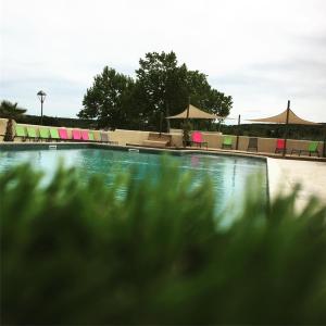 una gran piscina con sillas y mesas en Camping L'Evasion en Fontès