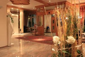 a living room with a lobby with flowers and plants at Airporthotel Salzburg - Hotel am Salzburg Airport in Salzburg