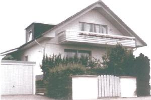ein weißes Haus mit einem Zaun davor in der Unterkunft Komfortferienwohnung in ruhiger Lage mit 128qm in Grömitz in Grömitz