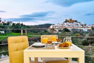 einen Tisch mit Speisen und Getränken auf einem Balkon mit Aussicht in der Unterkunft Quinta do Vau in Mértola