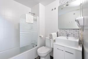 a white bathroom with a toilet and a sink at Apartamentos Globus by Be Alicante in Alicante