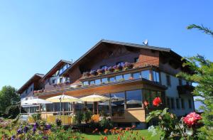 a building with umbrellas and flowers in front of it at Airporthotel Salzburg - Hotel am Salzburg Airport in Salzburg