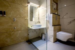 a bathroom with a toilet and a sink and a shower at The Fern Residency Vijayapura in Bijāpur +19 photos