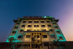 a tall building with a fence in front of it at The Fern Residency Vijayapura in Bijāpur