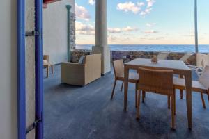 uma sala de jantar com mesa e cadeiras e o oceano em NerOssidiana em Acquacalda