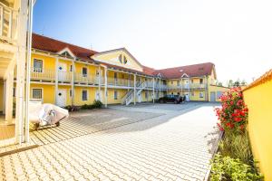 um pátio de um edifício com edifícios amarelos e brancos em Lipno - Seepark Residence em Horní Planá