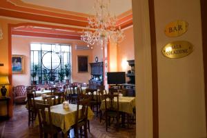 un comedor con mesas y sillas y una lámpara de araña en Hotel Principi D'Acaja, en Turín