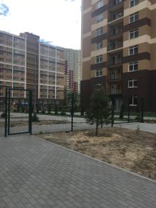 um parque com uma cerca e uma árvore em frente a alguns edifícios em ЖК Варшавский квартал, Правды 41 em Kiev