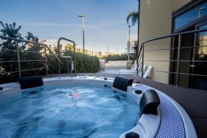 a jacuzzi tub on a balcony of a building at B&B Aloe Comfort Rooms in San Vito lo Capo
