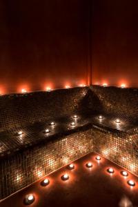 エリニコンにあるElafos Spa Hotelのタイル張りの壁の上に照明付きのバスルーム