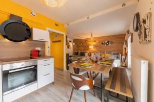 a kitchen with yellow walls and a table and chairs at The Modern Wood, Hyper centre, 8 Pers., T3 de 70m² in Voiron