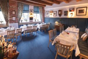 a dining room with tables and chairs and windows at Hotel Bremer Hof in Lüneburg