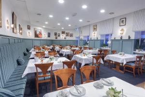 a dining room with white tables and chairs at Hotel Bremer Hof in Lüneburg