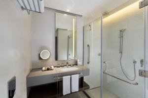 a bathroom with a sink and a shower at Millennium Place Barsha Heights Hotel in Dubai