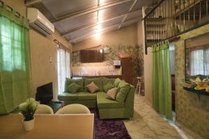 una sala de estar con un sofá verde en una habitación en Vacaciones Aregua CASA VANESSA en Areguá