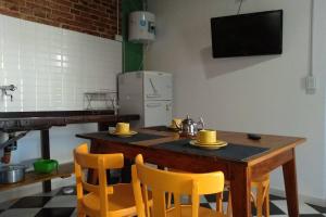 cocina con mesa de madera y sillas amarillas en Departamento Amoblado con Cochera en Villa María