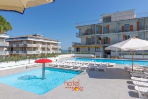 una piscina dell'hotel con sedie e ombrellone di Hotel Sole a Montesilvano