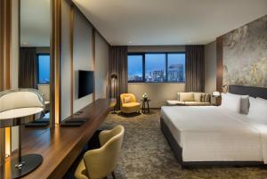 a hotel room with a bed and a desk at Millennium Place Barsha Heights Hotel in Dubai