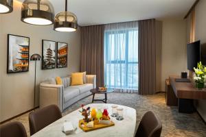 a living room with a couch and a table at Millennium Place Barsha Heights Hotel in Dubai