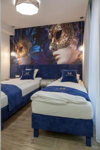 - 2 lits dans une chambre avec des masques sur le mur dans l'établissement Apartamenty Gdańsk EU - Angielska Grobla OLD TOWN Gdańsk sw Barbary 11, à Gdańsk